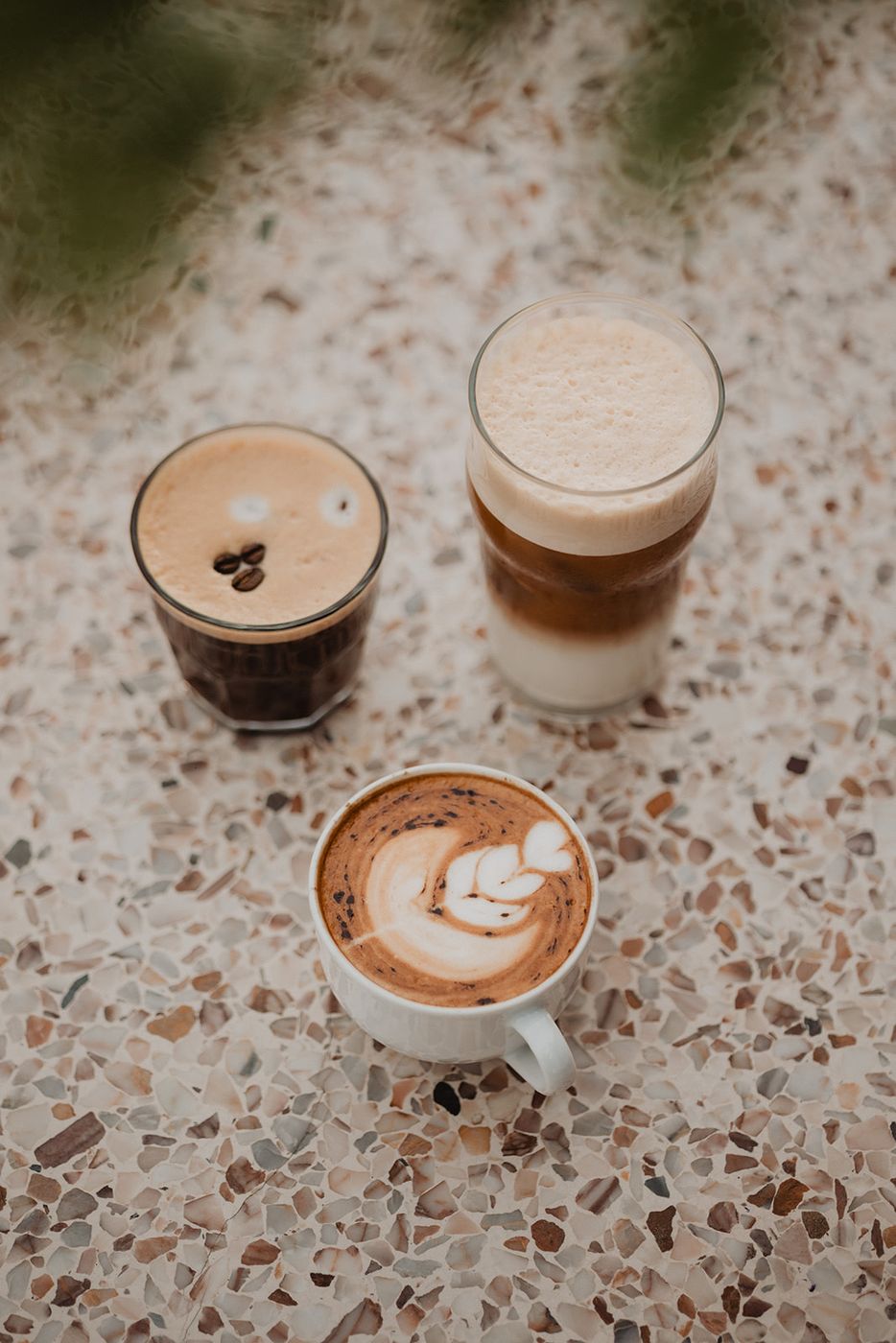 Espresso, iced latte and cappuccino on a terrazzo table
