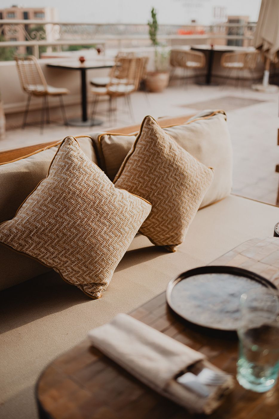 Banquette with woven cushions and a zellige table