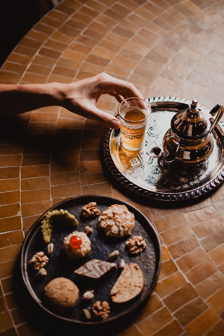 Mint tea poured at the table, silver teapot and pastries